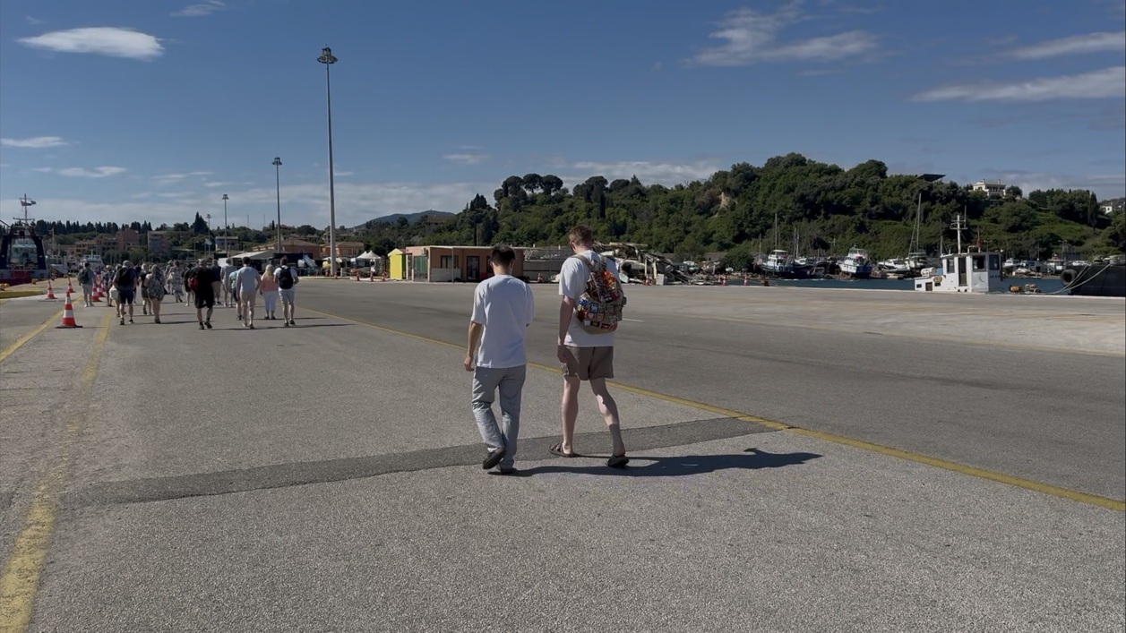 Passengers walking across the dock area at Corfu cruise port